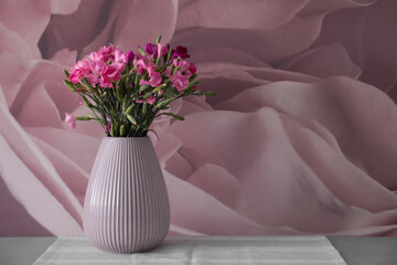 Vase with beautiful carnations on grey table. Space for text