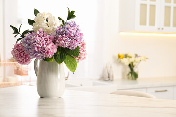 Bouquet with beautiful hydrangea flowers on white marble table. Space for text