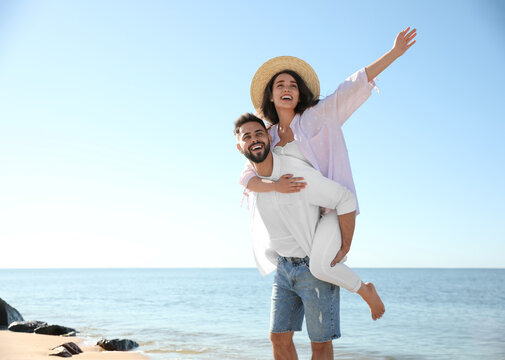 Happy young couple having fun at beach near sea. Honeymoon trip