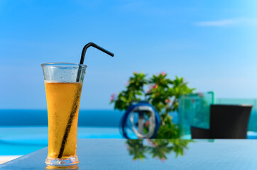 cup of fresh cold drink with an ocean at the far end