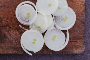 simple food ingredients, fresh onion cut into rings on cutting board