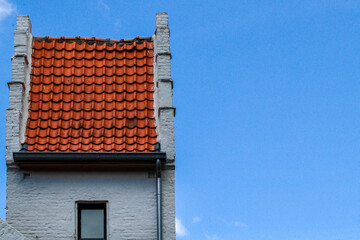 roof of the house.
A red tile roof and a part of a white old building on the left against the sky...