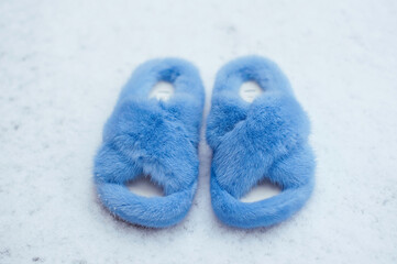 Fashionable blue female fur sandals on the snow. Outdoor street style. 