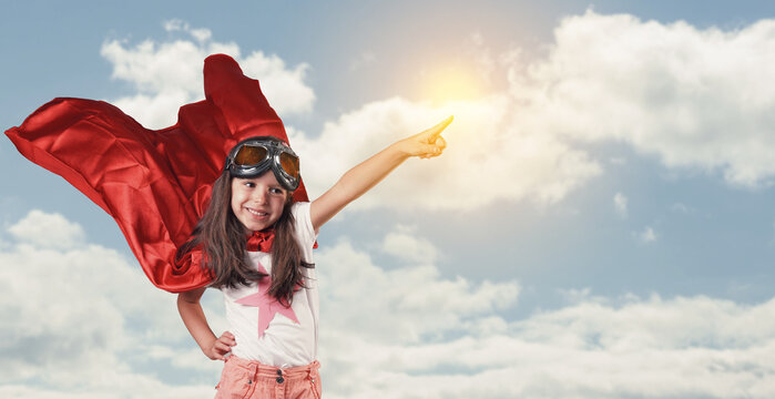 The little girl in a red cape is pointing forward with her hand. sky backdrops.