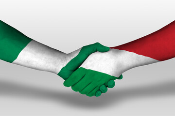 Handshake between hungary and nigeria flags painted on hands, illustration with clipping path.