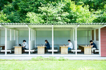 Men and woman are Working on an Outdoor Office that Set Social Distancing as New Normal Office Style