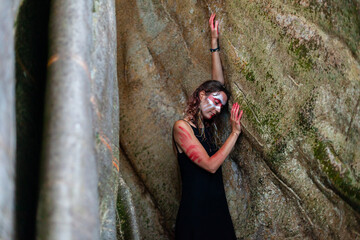Portrait of a girl with a painted face and an ancient tree.
Woman and nature.