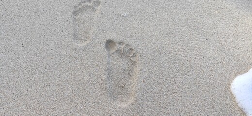 Fototapeta na wymiar footprints in the beach sand
