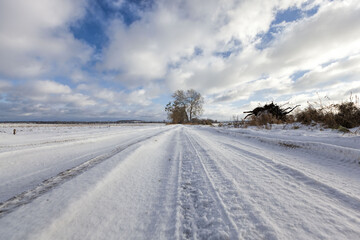 Fototapeta na wymiar narrow snow-covered winter road