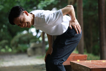腰に痛みを感じる男性