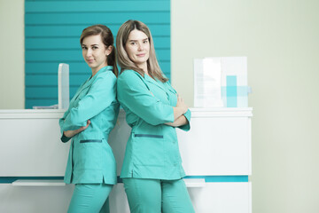 Two female doctors or nurses looking at the camera. In the hospital reception