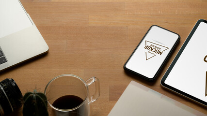 Worktable with copy space, mock up smartphone, tablet, laptop, camera and office supplies