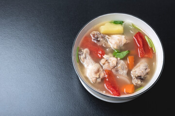 Clear chicken soup in a white bowl