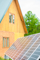 Solar panels stand near rustic house at forest