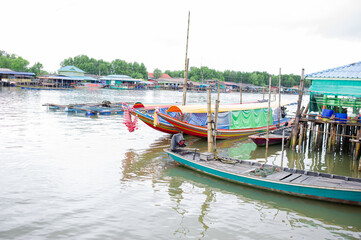 Long-tailed boats are on the waterfront in a fishing village