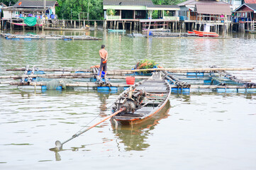 Long-tailed boats are on the waterfront in a fishing village