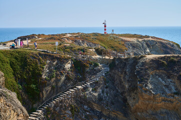 Fototapeta na wymiar lighthouse of Porto Covo and stone stair to the beach