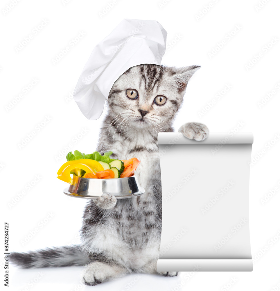 Poster kitten wearing chef's hat holds bowl of the vegetables and empty list. isolated on white background