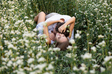 couple embracing lying in the grass on the meadow