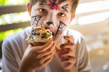 Boy eating spooky Halloween cupcakes
