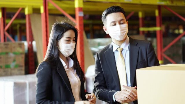 Business people in face mask as new normal discuss in warehouse