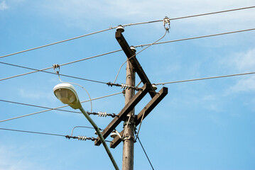 High voltage electricity transmission pole and public lighting lamp in Latin America.