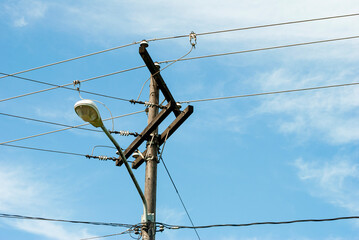 High voltage electricity transmission pole and public lighting lamp in Latin America.