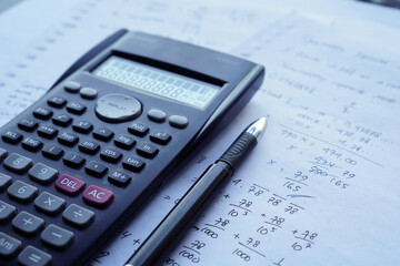 scientific math workout. sheet paper with solving equation math next to calculator