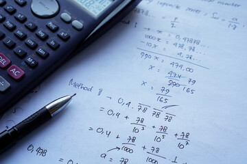 scientific math workout. sheet paper with solving equation math next to calculator