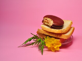 Dry rusk bread and choco pie chocolate on pink background. Healhty breakfast menu