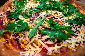 Pizza with fresh green arugula, parmesan cheese and cherry tomatoes food background. Freshly baked homemade pizza