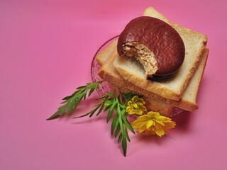 Dry rusk bread and choco pie chocolate on pink background. Healhty breakfast menu