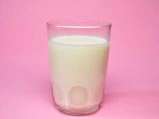 A glass of milk isolated on pink background. Fresh milk