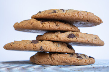 Exquisite homemade chocolate chip cookies stacked on a table and with white background.