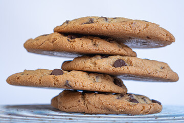 Exquisite homemade chocolate chip cookies stacked on a table and with white background.