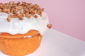 Delicious homemade cinnamon roll with creamy white topping and walnut chunks on top.