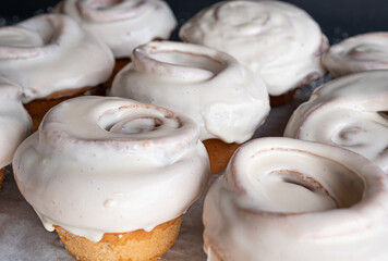 Exquisite homemade cinnamon rolls covered in white frosting.