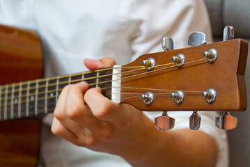 Young boy playing guitar. Close-up of man hand playing classic guitar. teenager learning playing guitar.