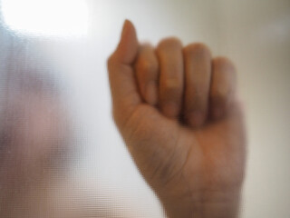 A girl holding her hands tarnished frosted glass background