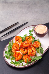 Hot appetizer fried king shrimps, arugula, sauce