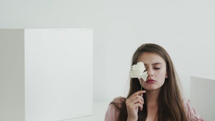Attractive beautiful young woman model with flowers looking and posing at camera