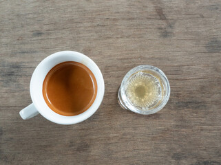 Espresso coffee in a white cup with a glass of honey, Hot drink with gray wooden table in background	