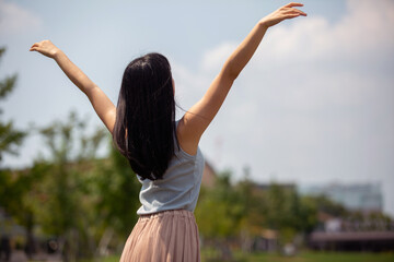 空に向かって手を広げる女性