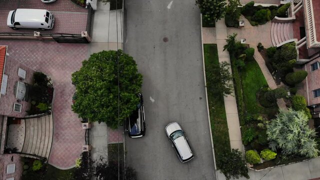 Aerial Shot Of Car Pulling Out Of Driveway In Suburbs