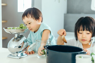 男の子と女の子兄弟が家のキッチンで料理のお手伝いをしている