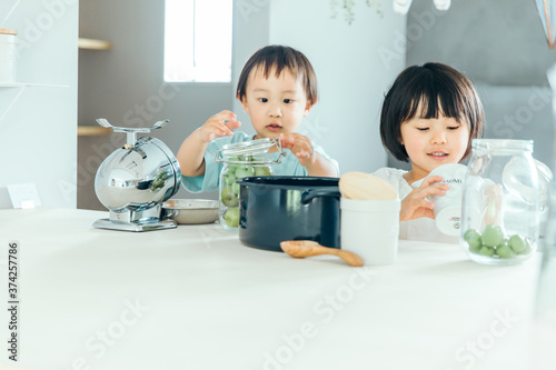 男の子と女の子兄弟が家のキッチンで料理のお手伝いをしている Wall Mural 健二 中村 男の子と女の子兄弟が家のキッチンで料理のお手伝いをしている Wall Mural 健二 中村