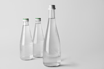 Bottles of clean water on light background