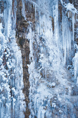 Icicles on the rock. Frozen waterfall in winter.