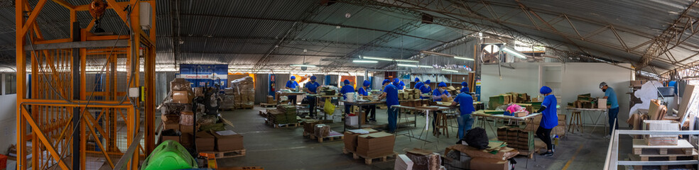 Fototapeta na wymiar Fotografía panorámica de un grupo de trabajadores en su labor en una fábrica de imprenta
