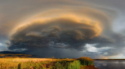 A thunderhead over the wetlands near the Great Salt Lake. Also a rainbow can be seen in the distance